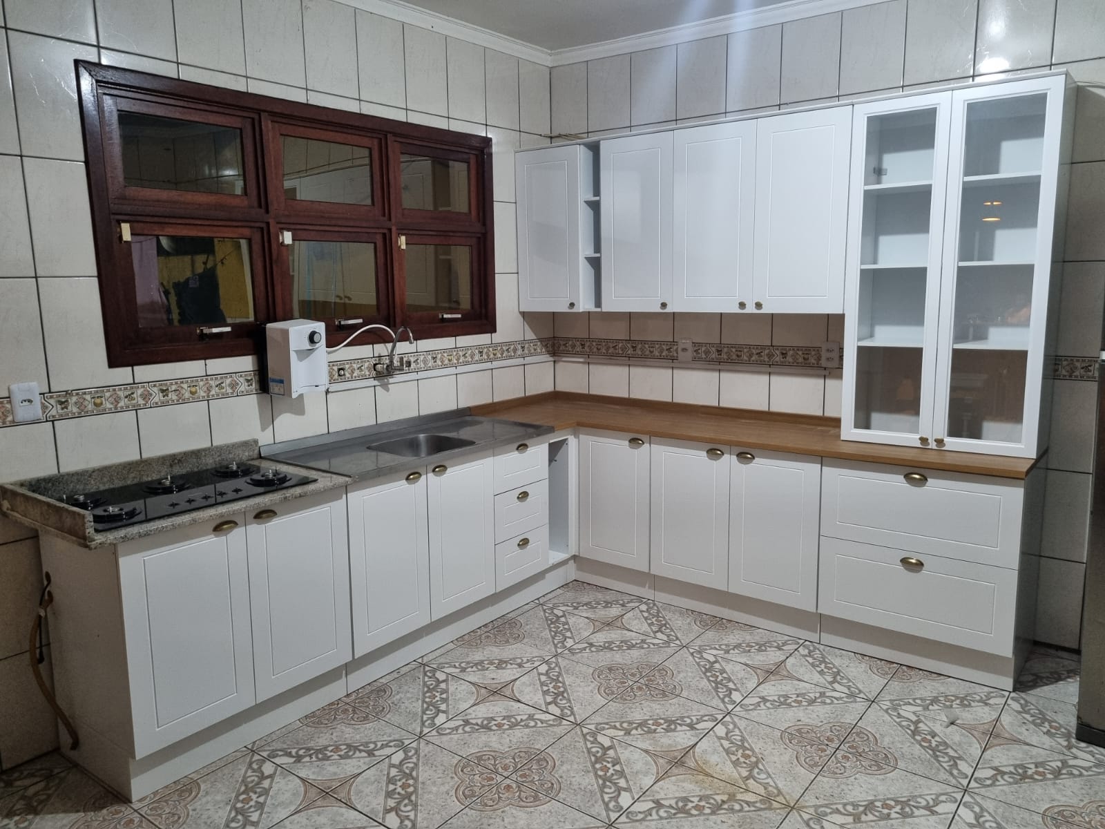 Cozinha em L com armários brancos