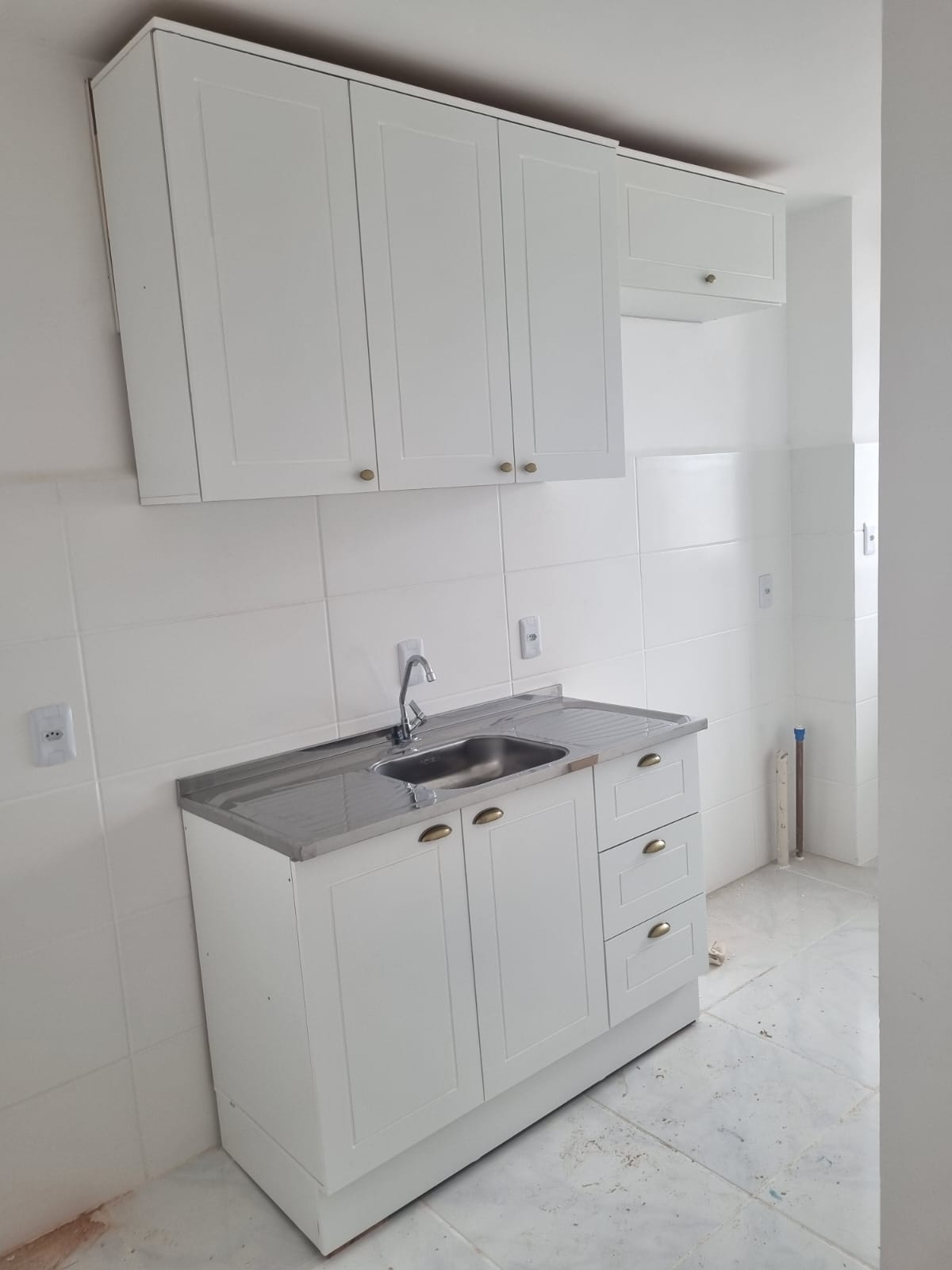 Cozinha compacta com armários brancos